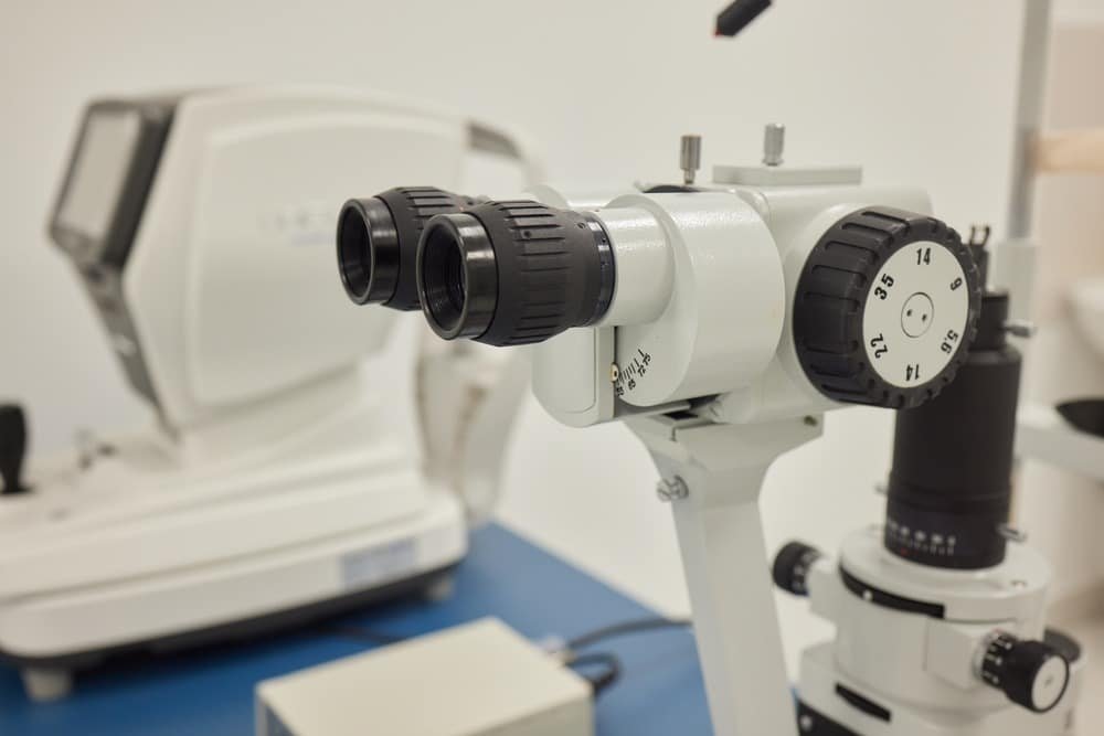 Close-up view of a slit lamp showing its microscope and illumination system.